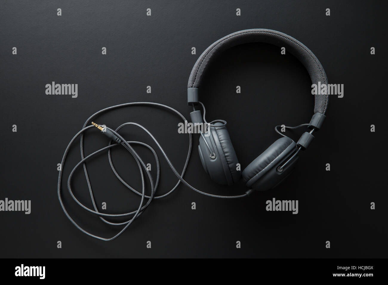 Schwarze Retro-Kopfhörer auf schwarzem Hintergrund. Stockfoto