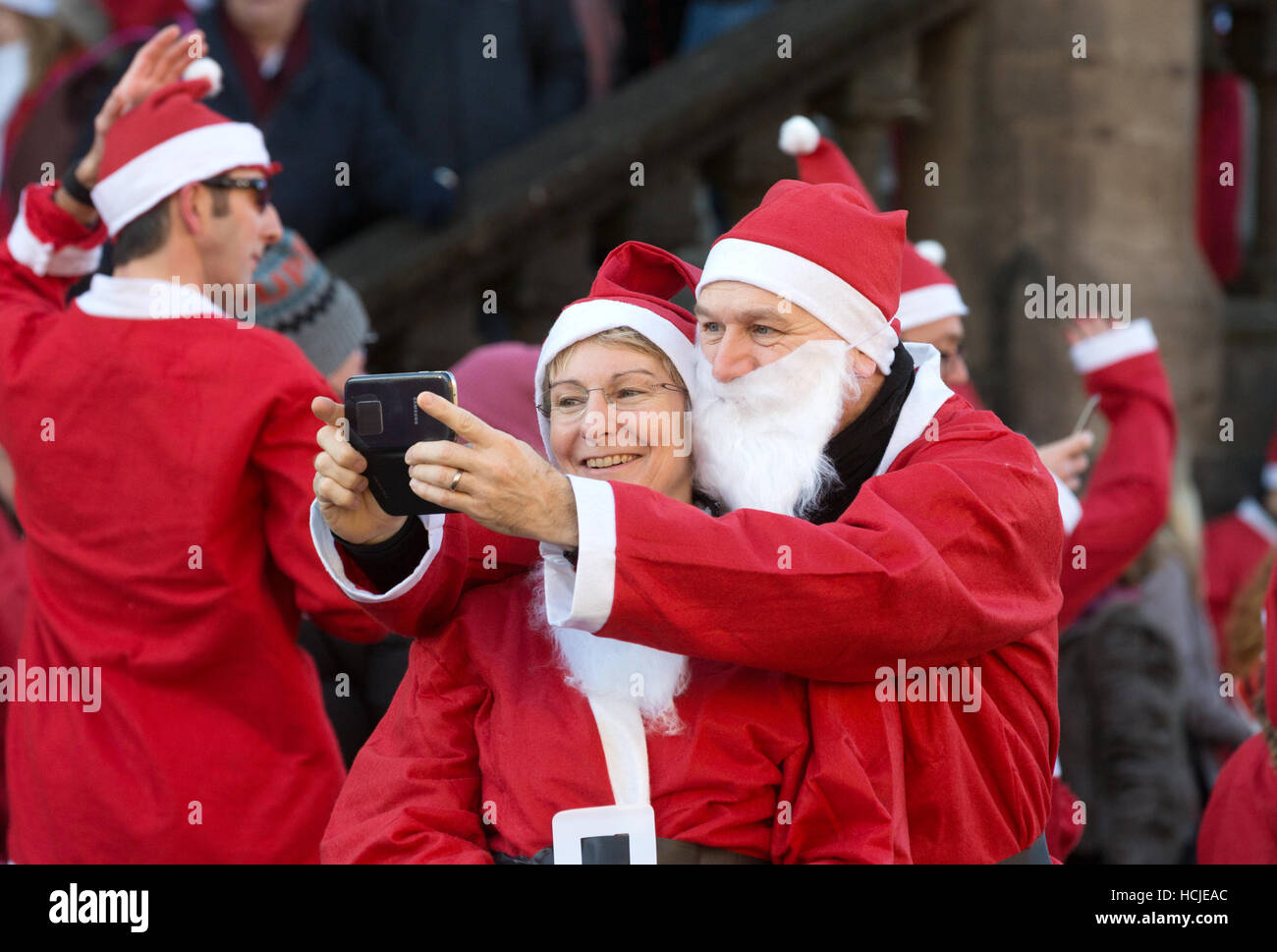 Paar verkleidet als Weihnachtsmann, wobei eine Selfie, Winchester, Hampshire, UK Stockfoto