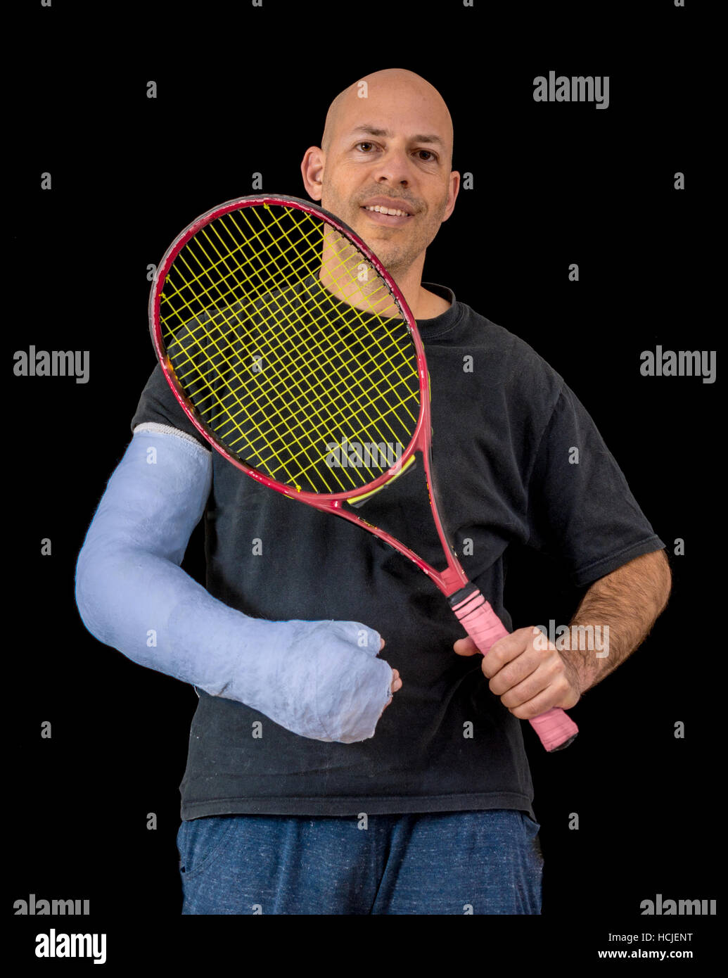 Junger Mann hält einen Tennisschläger nach seinem Handgelenk zu brechen, in einem Tennis-Spiel, ein helles Blau sportliche arm gegossen, isoliert auf schwarz Stockfoto