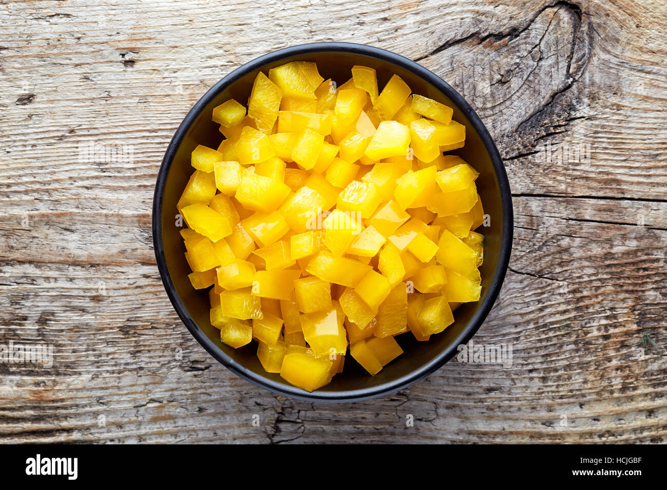 Schüssel mit gehackten Paprika auf hölzernen Hintergrund, Ansicht von oben Stockfoto