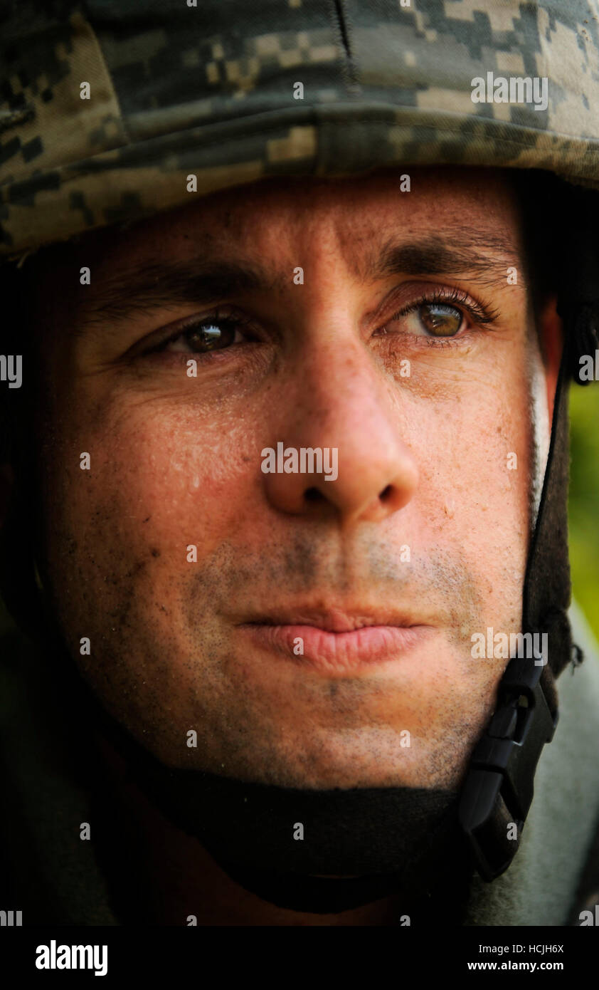 Ein Soldat zeigt den richtigen Verschleiß Body Armor. Die Soldaten Grimassen leicht wie Pools auf seine Augenlider zu schwitzen. Stockfoto