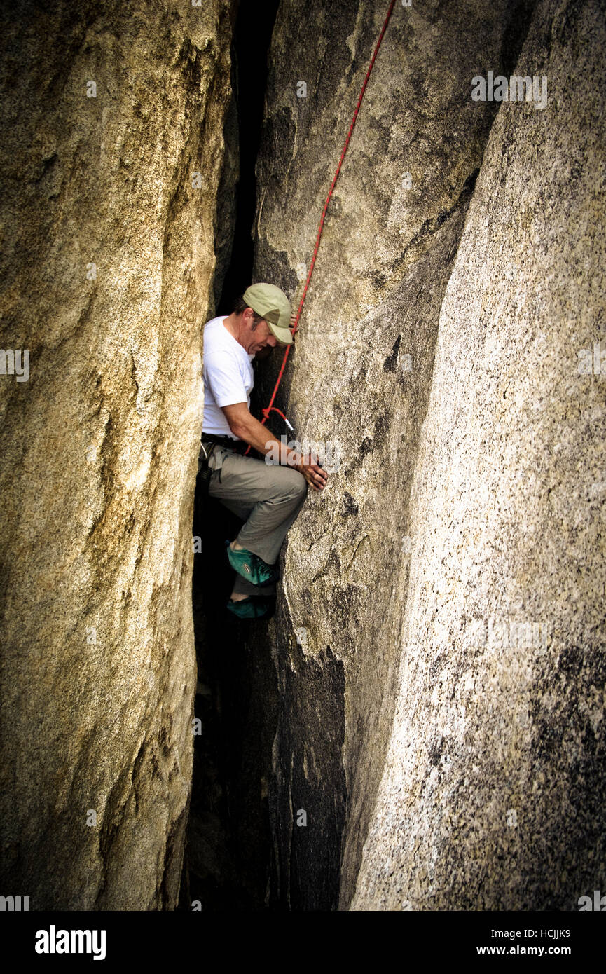 Roy Smith klettert ein breiter Riss treffend benannt "Jaws" in Joshua Tree, Kalifornien. Stockfoto