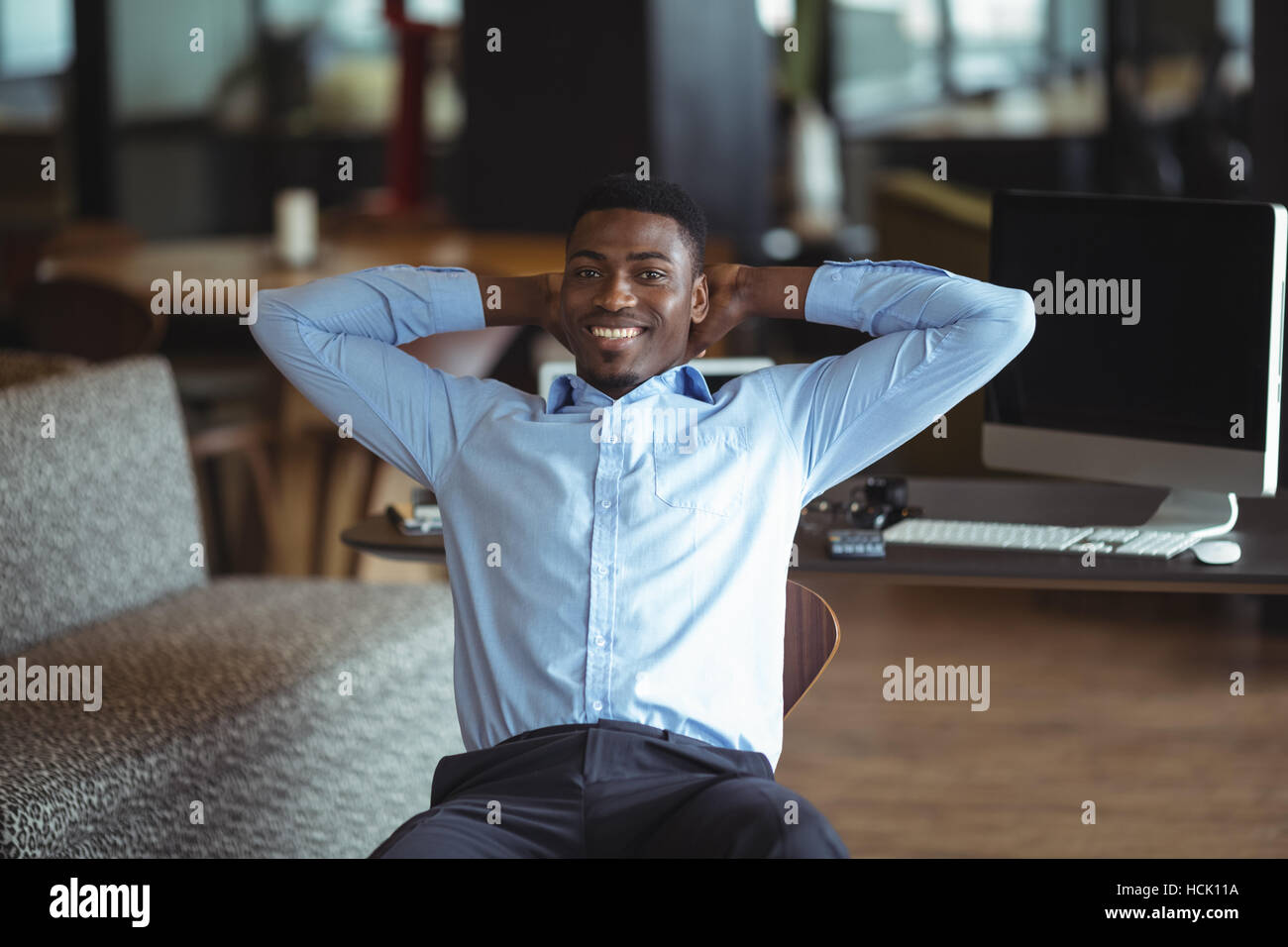 Lächelnde Geschäftsmann auf Stuhl sitzend Stockfoto