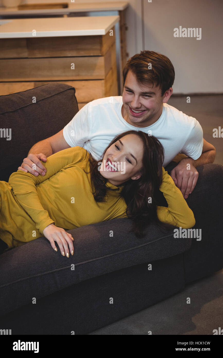 Fröhliches paar liegen zusammen auf dem Sofa im Wohnzimmer Stockfoto