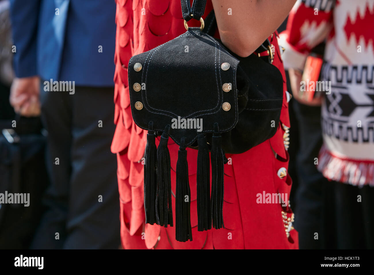 Frau mit rotem Kleid und V 73 schwarzer Rucksack mit Fransen vor Stella Jean Modenschau, Milan Fashion Week Streetstyle. Stockfoto