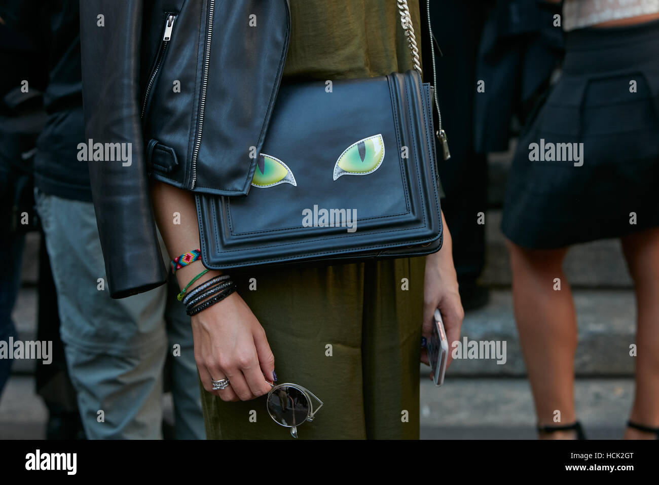 Frau mit schwarzen Tasche mit grünen Katzenaugen vor Salvatore Ferragamo Modenschau, Milan Fashion Week Streetstyle am September. Stockfoto