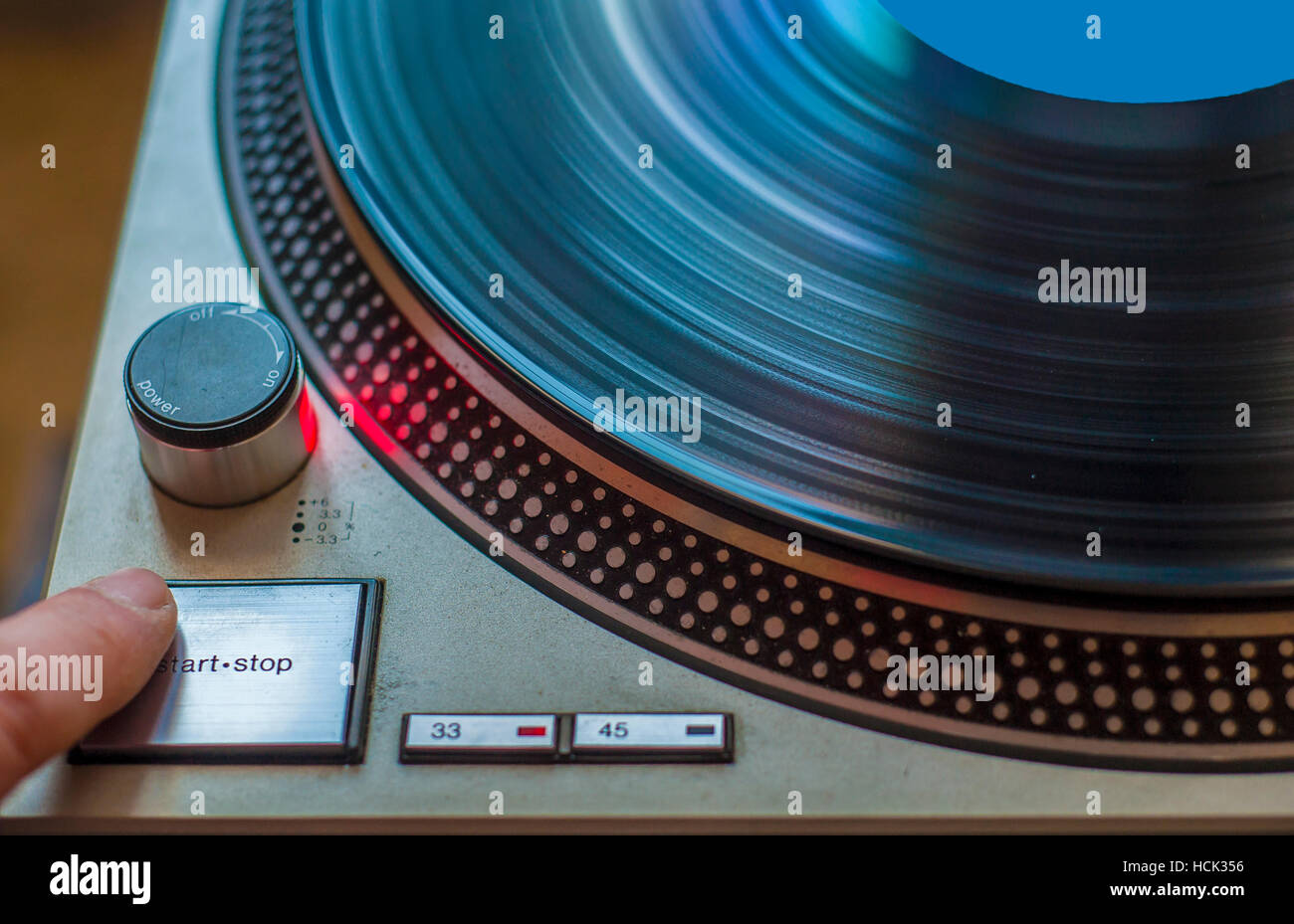 Ein Fan von HiFi-Musik beginnt den Plattenspieler zum Abspielen von vinyl Stockfoto