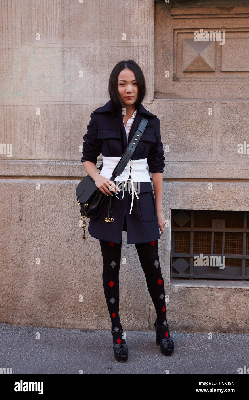 Frau mit schwarzen und weißen Kleidern und Schwarze Ledertasche vor Prada Modenschau, Milan Fashion Week Streetstyle Stockfoto