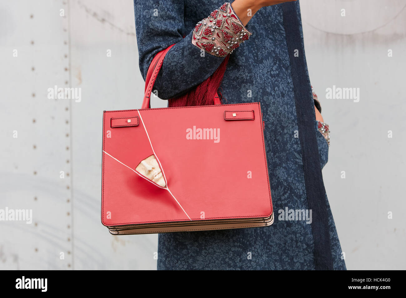 Frau mit roten Tasche mit Skulptur Gesicht bevor Gucci Modenschau, Milan Fashion Week Streetstyle am 21. September in Mailand. Stockfoto