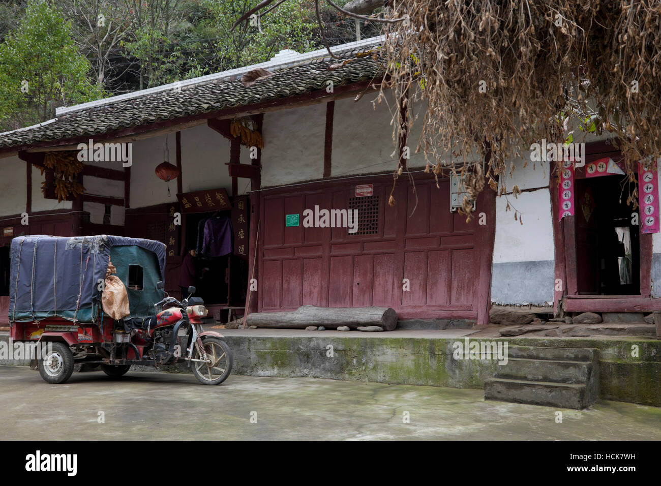 Ein Motorrad angetriebene Wagen parkten außerhalb ein traditionelles Bauernhaus in einem ländlichen Ort in Südwest-China. Stockfoto