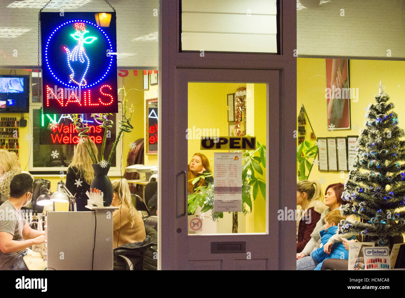 Geschäftiger Nail Bar Shop, Neon-Schilder und Einkäufer im Einzelhandel der Stadt Chester, Cheshire, Großbritannien Stockfoto