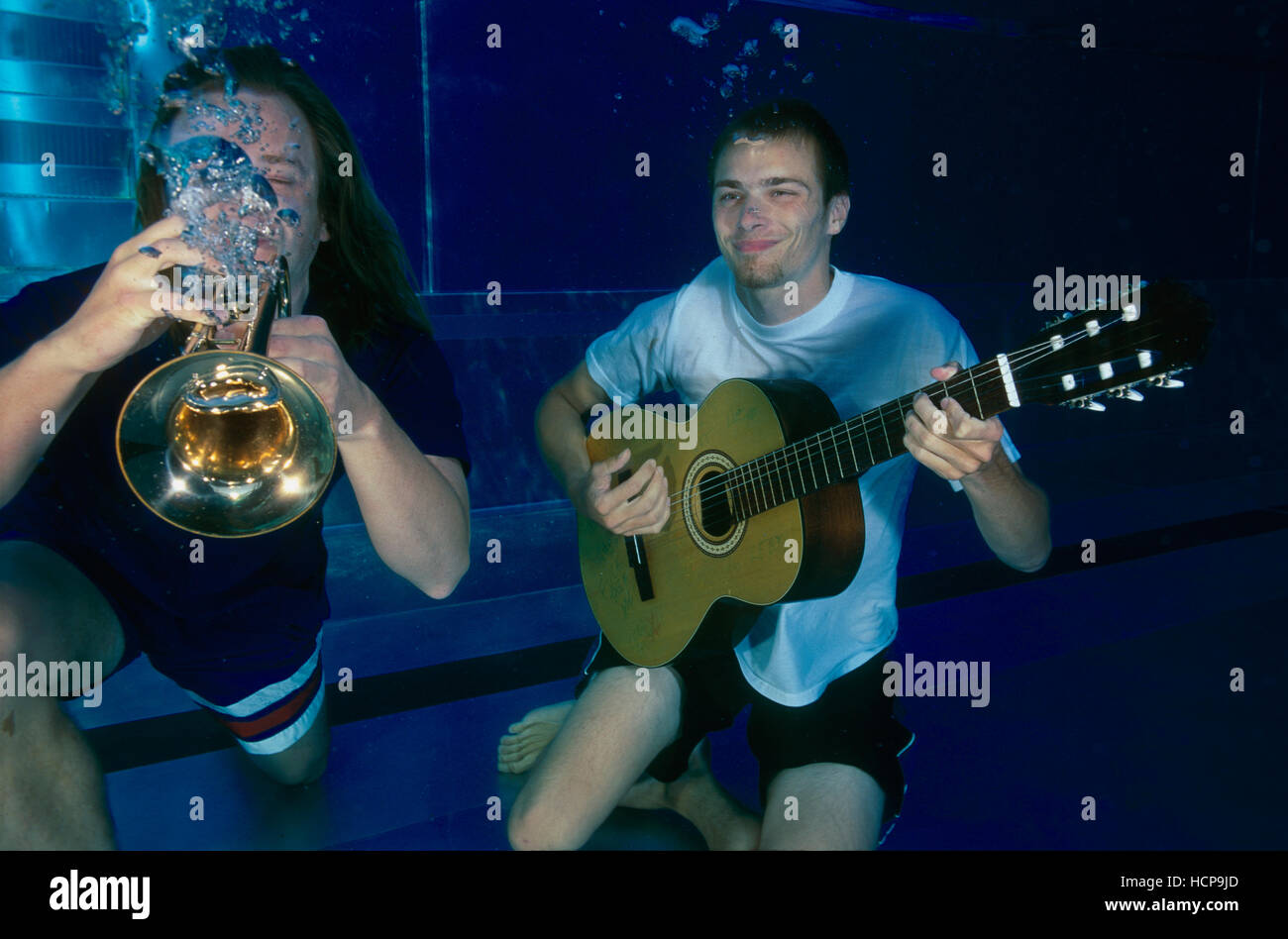 Musiker spielen Trompete und Gitarre unter Wasser Stockfoto