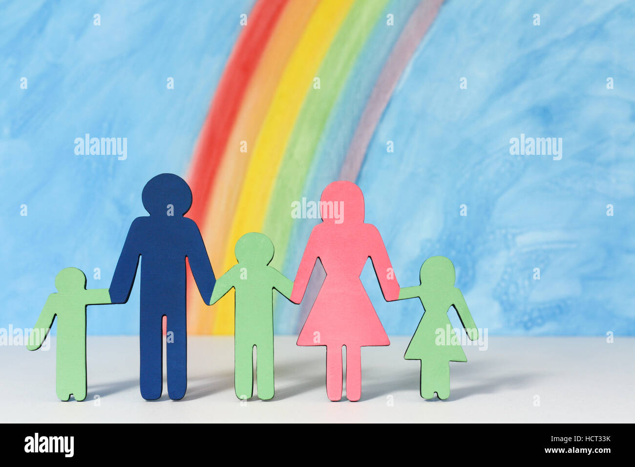 Vater, Mutter und Kinder Symbole mit einem Regenbogen und blauer Himmel zur Veranschaulichung des Konzepts der traditionellen Familie Ehe; Nahaufnahme Stockfoto
