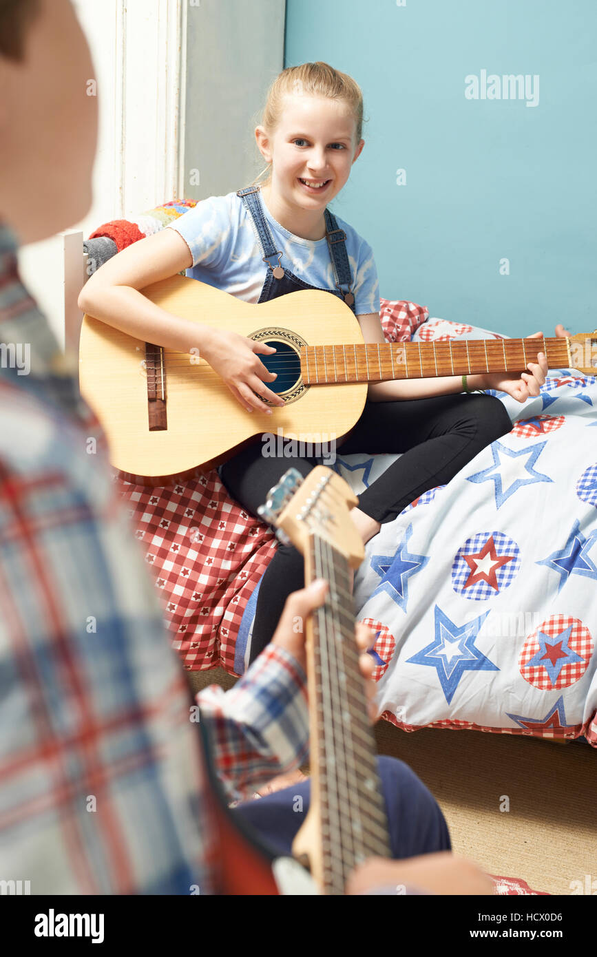 Kinder im Schlafzimmer spielen Gitarren zusammen Stockfoto