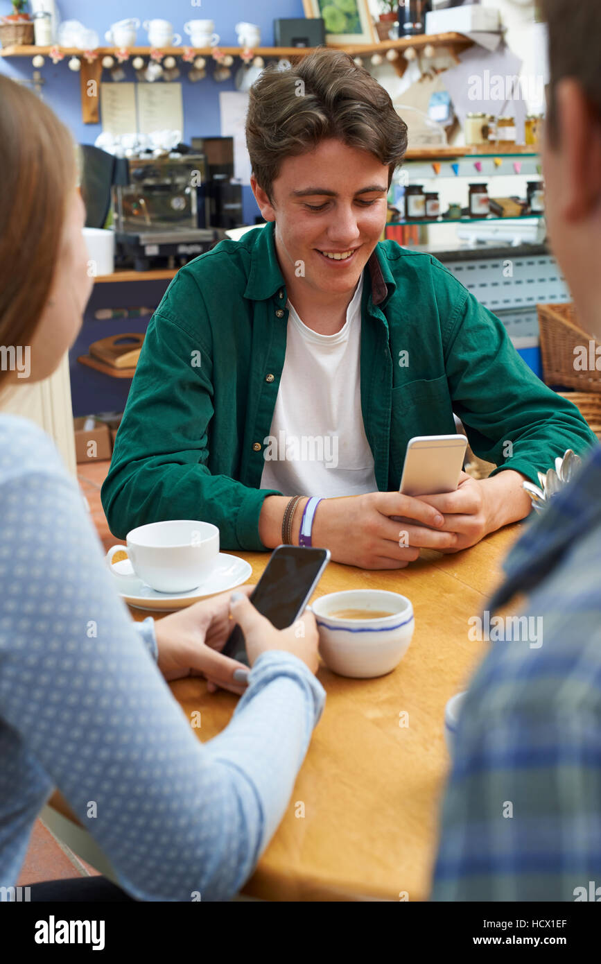 Gruppe von Jugendlichen Freunde treffen im Cafe und Benutzung von Mobiltelefonen Stockfoto