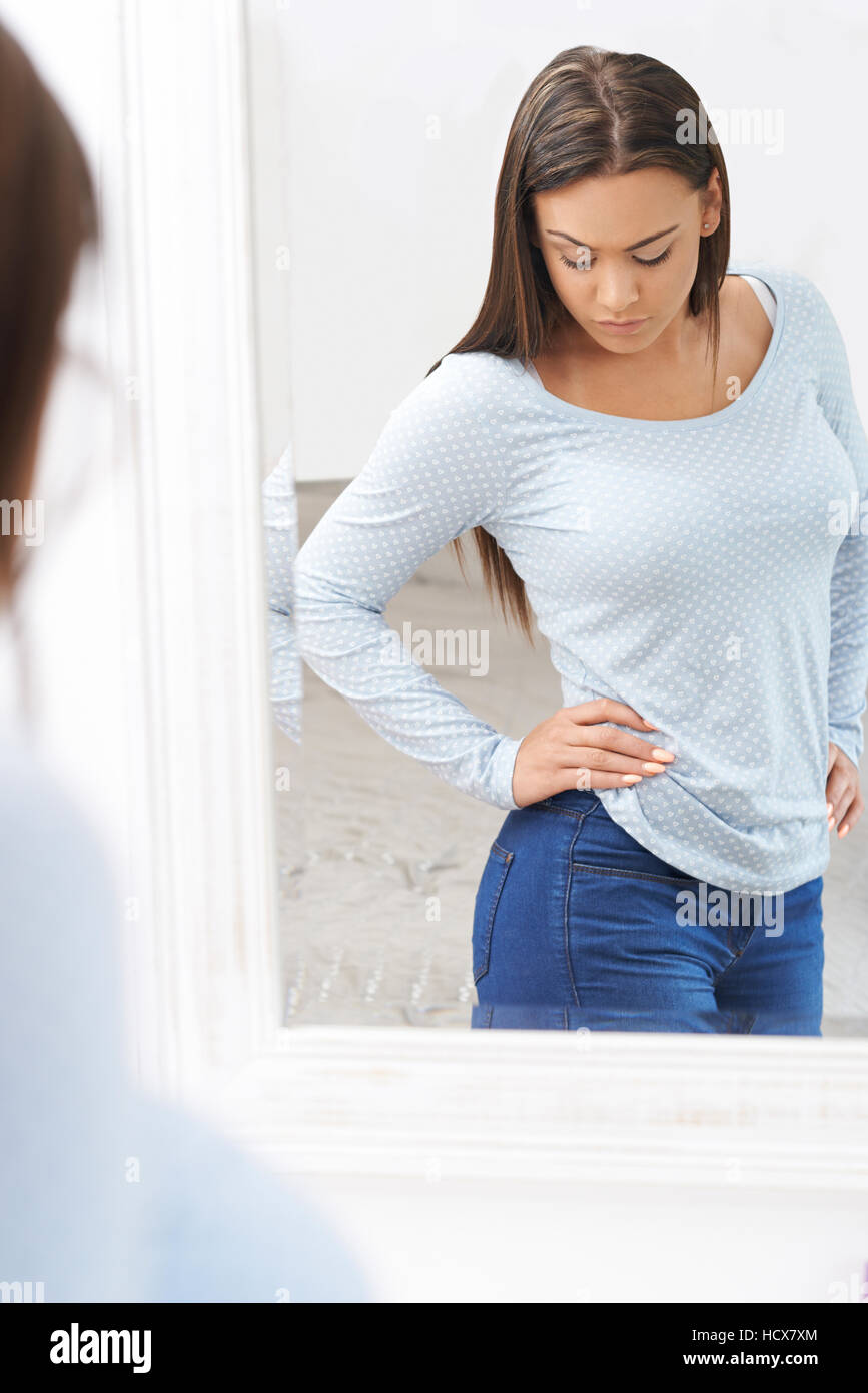 Unglücklichen Mädchens Reflexion im Spiegel zu betrachten Stockfoto
