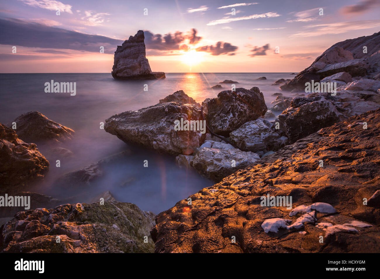 Klippen und Meer, eingerahmt von den rosa Himmel bei Sonnenaufgang, Strand La Vela, Portonovo, Provinz Ancona, Conero Riviera, Marche, Italien Stockfoto