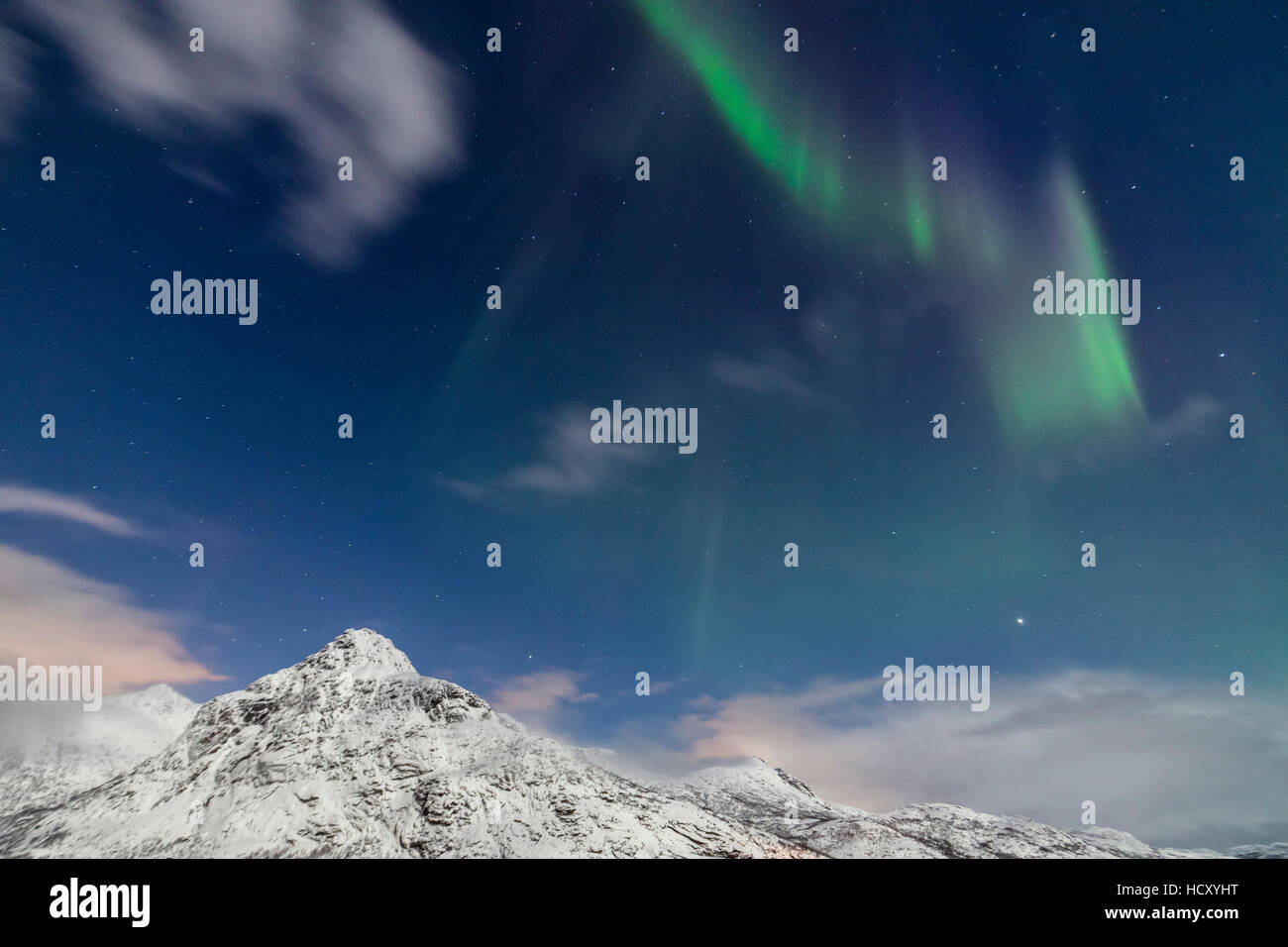 Nordlicht und Sterne leuchten auf den schneebedeckten Gipfeln, Vareid, Flakstad, Nordland, Lofoten-Inseln, Nord-Norwegen Stockfoto