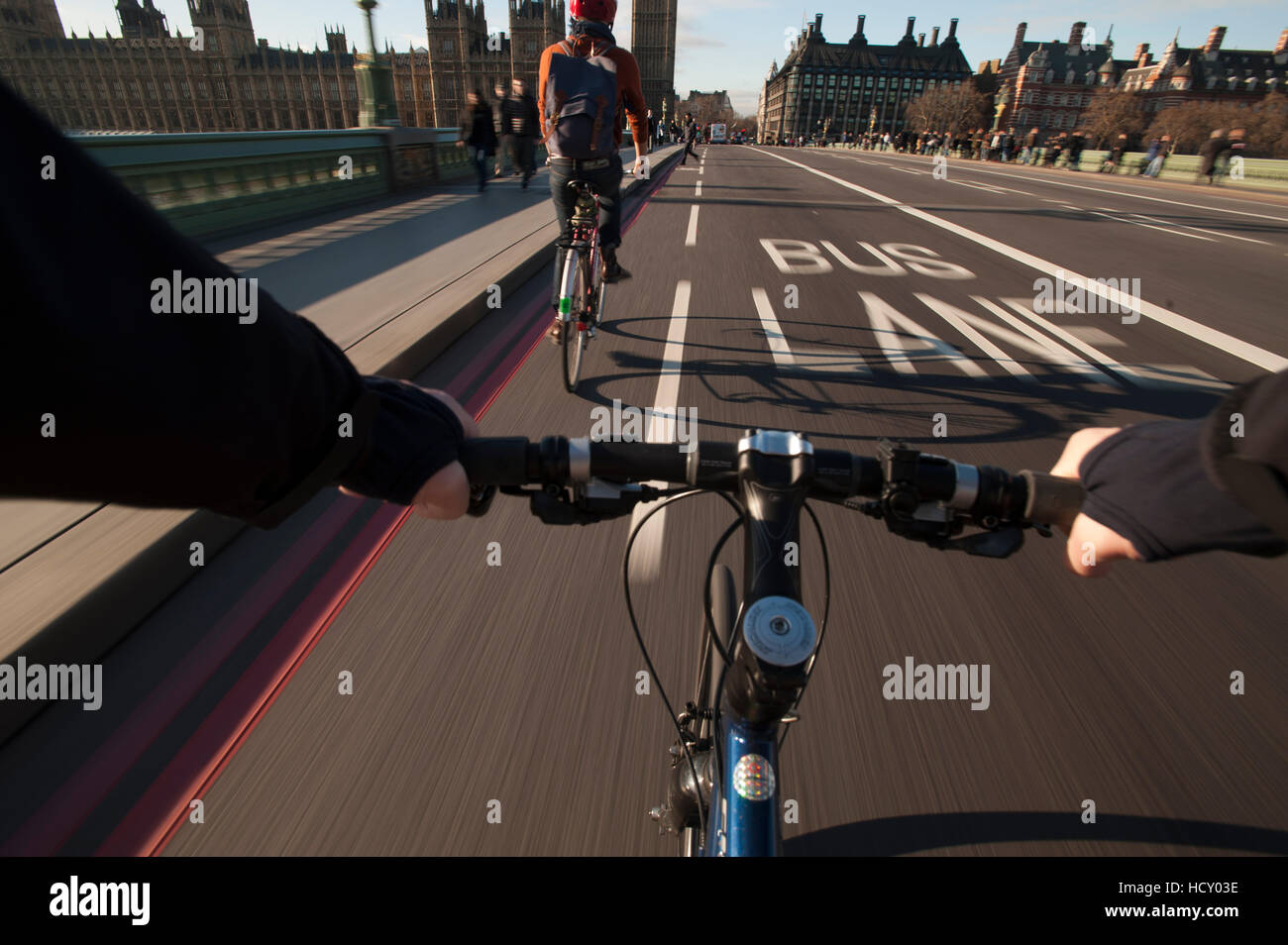 Ein Radfahrer überquert Westminster Bridge in Richtung der Houses of Parliament, London, UK Stockfoto