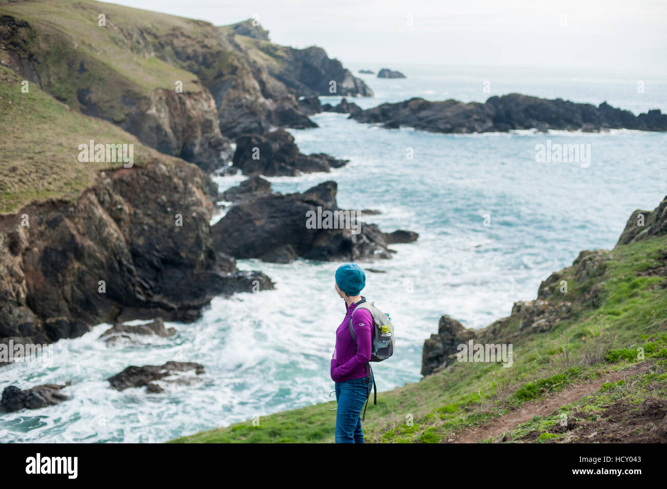 Eine Frau Wandern Küstenweg auf der Westseite der Halbinsel The Lizard, Cornwall, UK Stockfoto