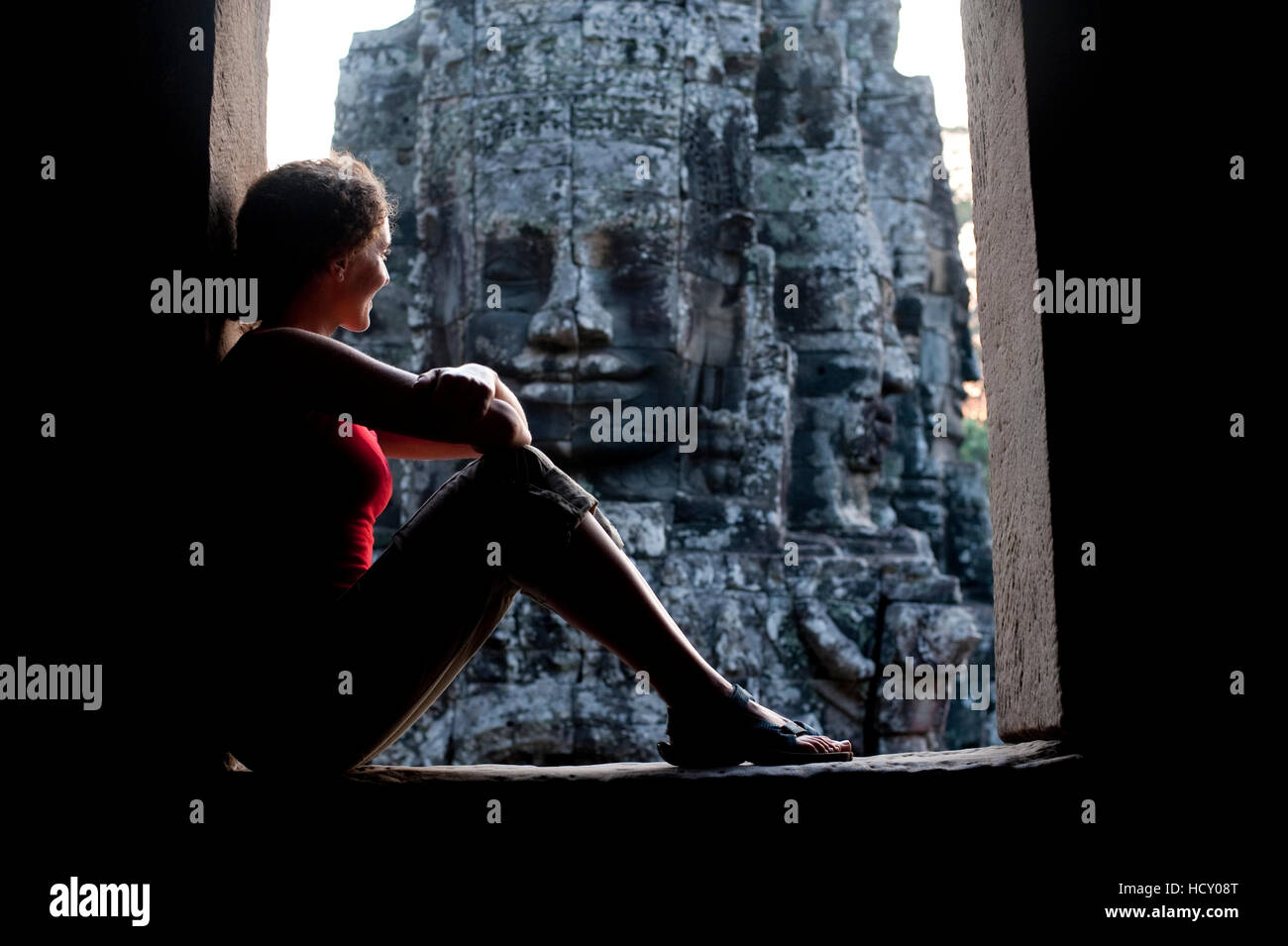 Ein Tourist schaut aus einer der Türen am Bayon Tempel in Angkor, UNESCO, Siem Reap, Kambodscha, Indochina Stockfoto