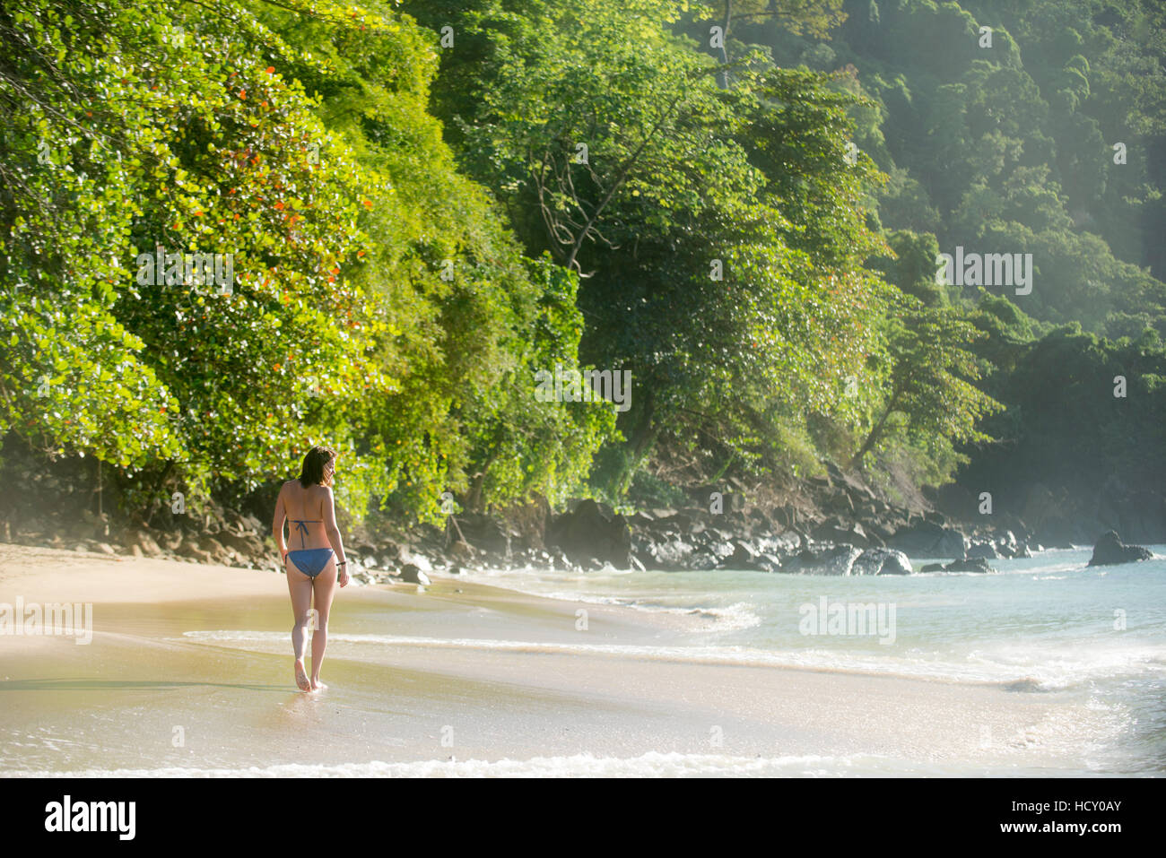 Eine Frau zu Fuß am Strand von Castara Bay auf der Karibikinsel Tobago, Trinidad und Tobago, West Indies, Karibik Stockfoto