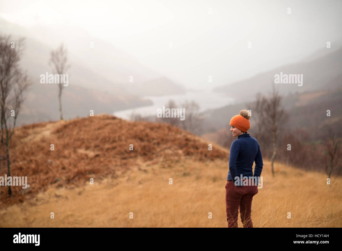 Eine Frau, in der Nähe von Kinlochlevan mit nebligen Blick auf Loch Leven, Perth und Kinross, Highlands, Schottland, UK Stockfoto