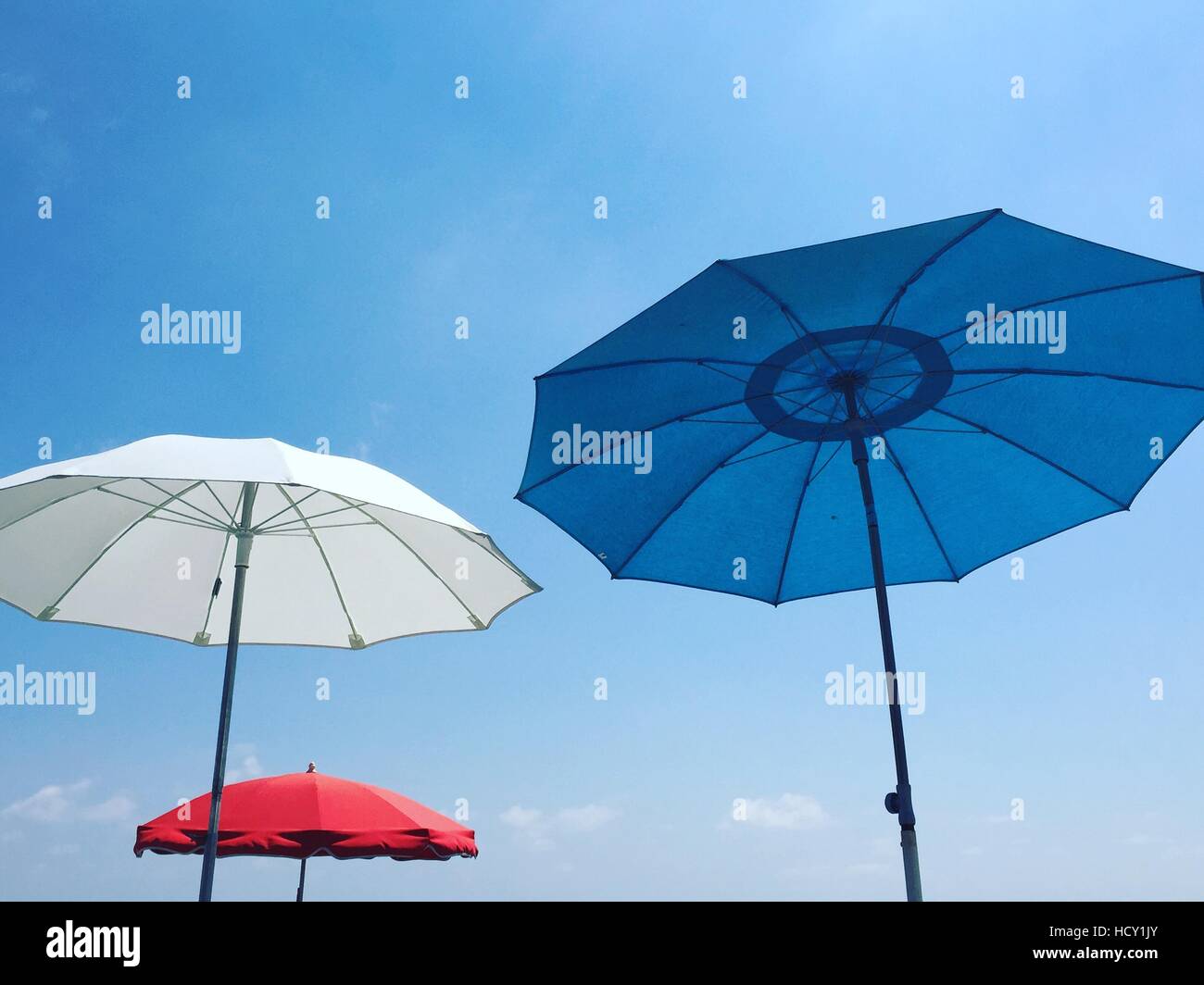 Rot, weiß und blau Strand Sonnenschirme vor blauem Himmel, Alpes Maritimes, Cote d ' Azur, Côte d ' Azur, Provence, Nizza, Frankreich Stockfoto
