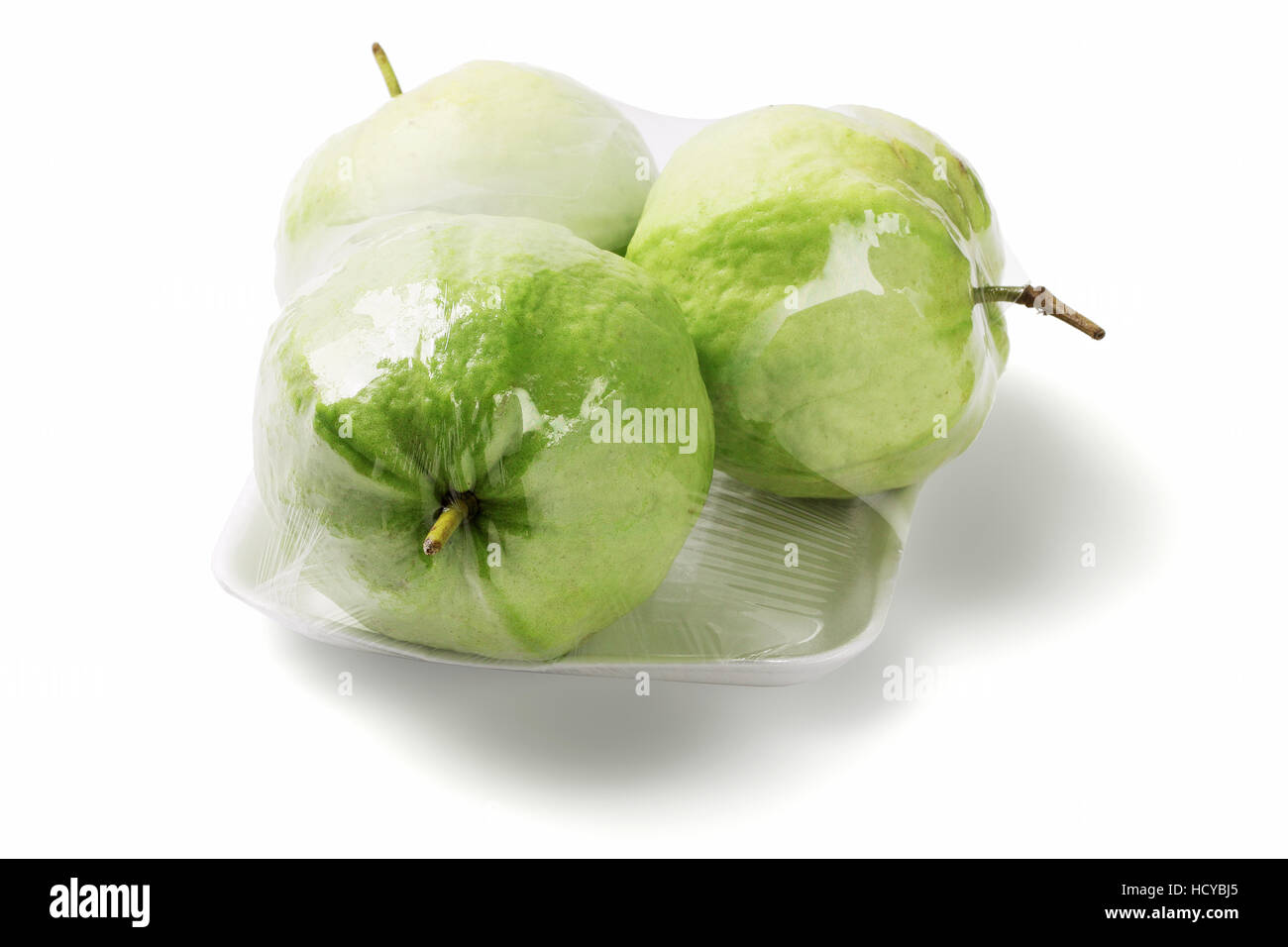 Drei Guave Früchte in Cellophan wickeln Sie auf weißem Hintergrund (Guave Guajava) Stockfoto