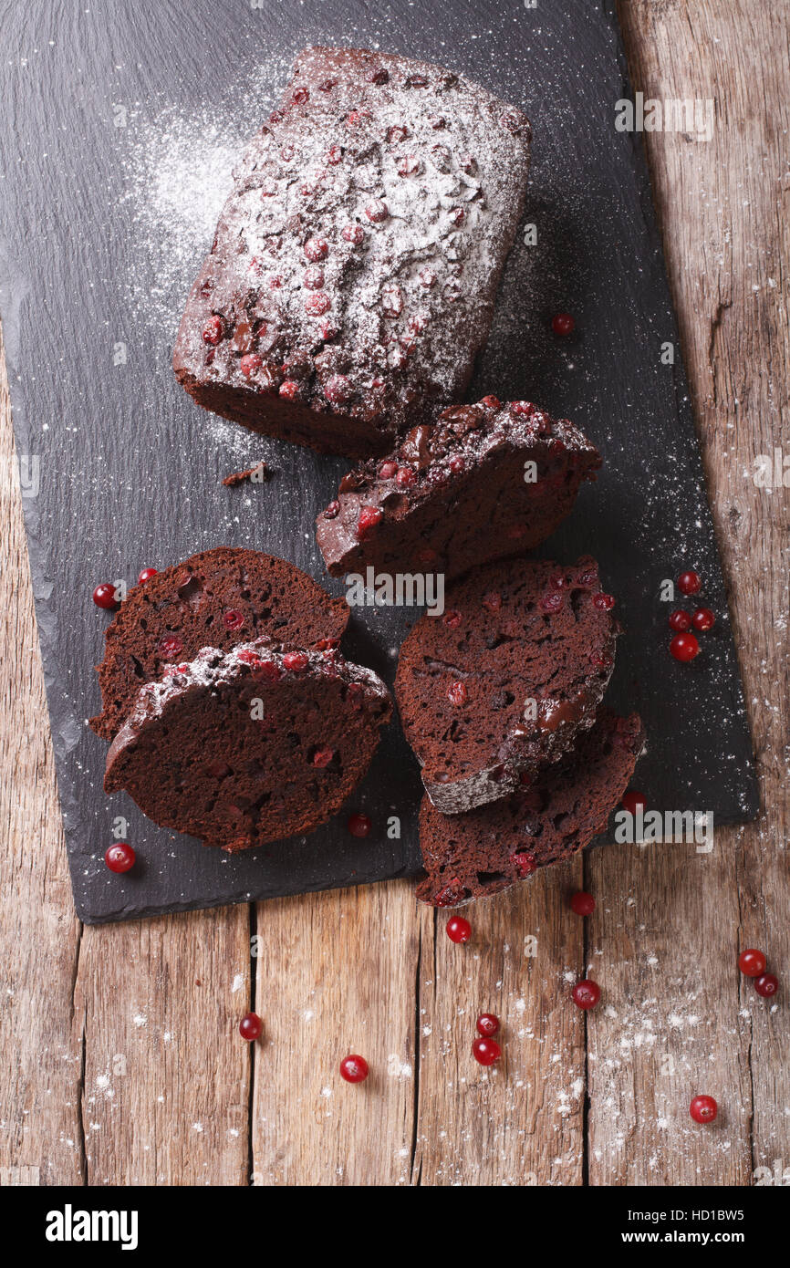 Geschnittene Schokolade Torte gefüllt mit Preiselbeeren Nahaufnahme auf dem Tisch. vertikale Ansicht von oben Stockfoto