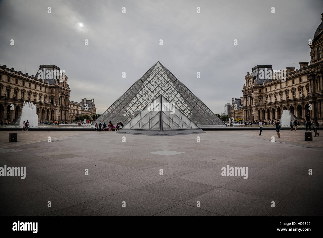 Louvre-Pyramide des Museums mit bewölktem Himmel. Stockfoto