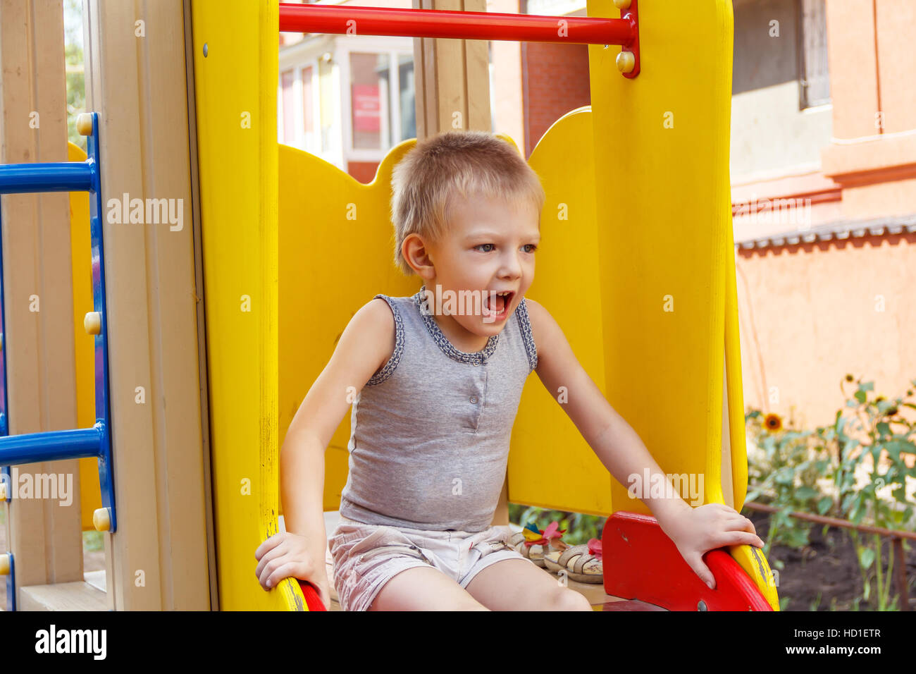 Kleines Kind laut schreiend auf Spielplatz im freien Stockfoto