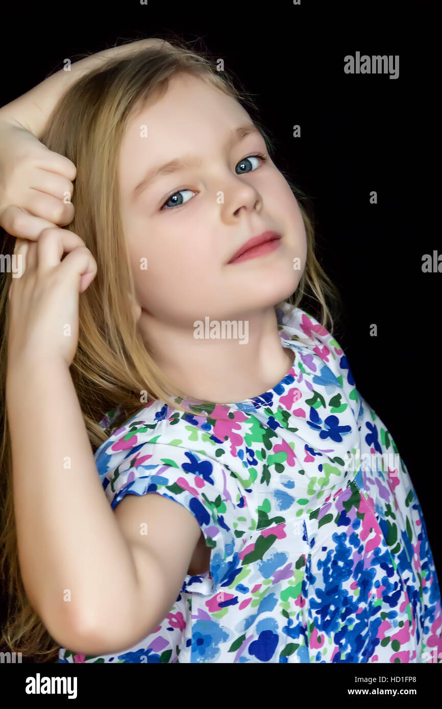 Niedliche Mädchen tanzen im blauen Kleid auf schwarzem Hintergrund Stockfoto