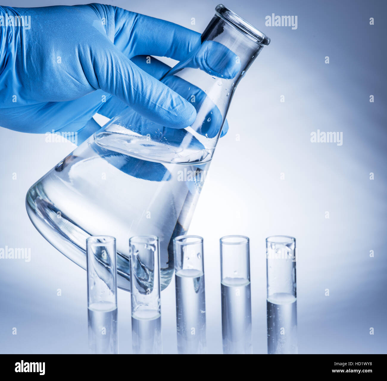 Labor-Becher in der Hand des Analytikers in Kunststoff-Handschuh. Stockfoto