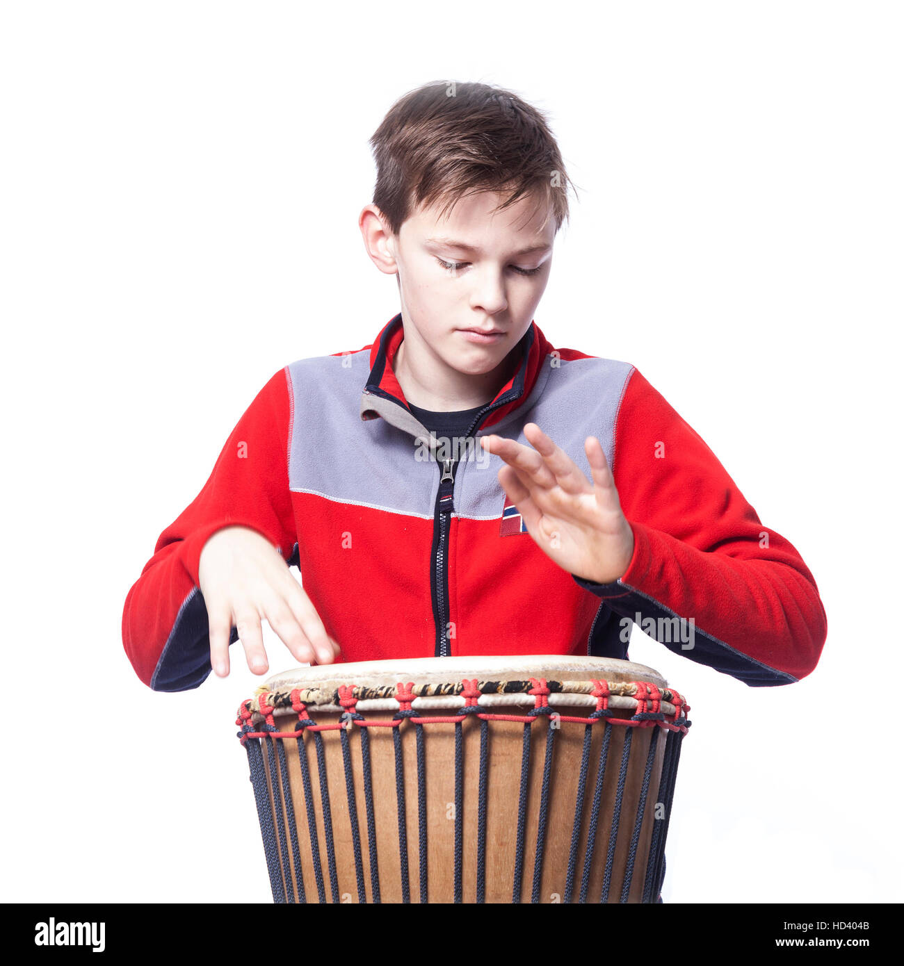 Kaukasische Teenager spielt die Djembe im Studio mit weißem Hintergrund Stockfoto