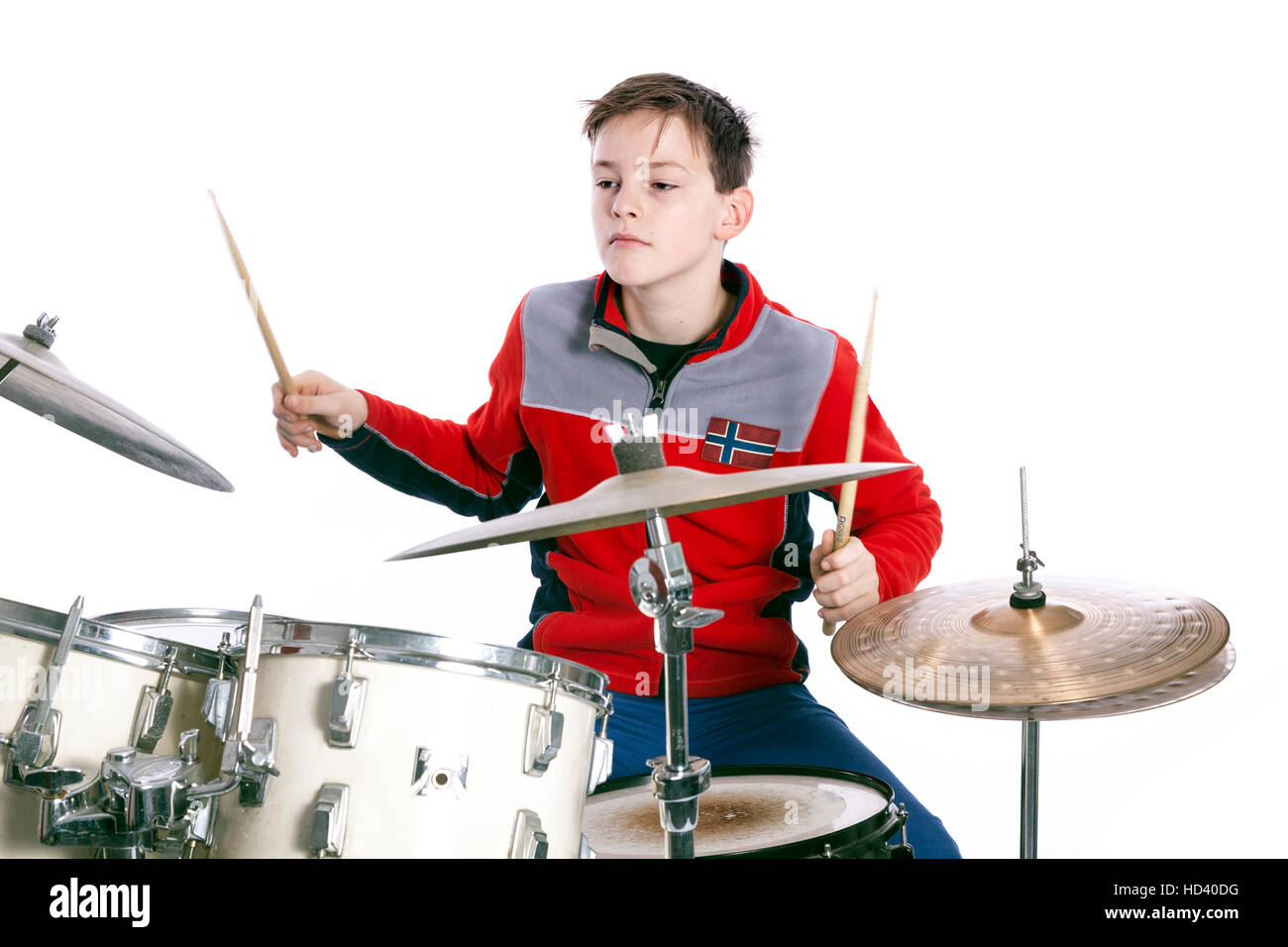 Kaukasische Teenager spielt Schlagzeug in Studio mit weißem Hintergrund Stockfoto