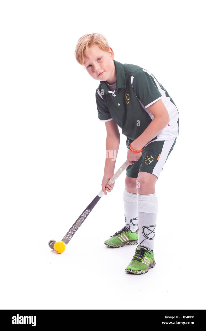 blonde kaukasische junge mit Feld-Hockey-Stick und Ball vor weißem Hintergrund Stockfoto