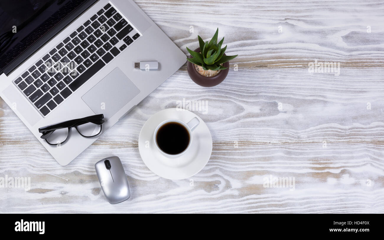Draufsicht auf ein mobiles Büro-Arbeitsplatz mit Laptop-Tastatur, dunklen Kaffee, Lesebrille, Anlage, USB-Stick und Funkmaus Stockfoto