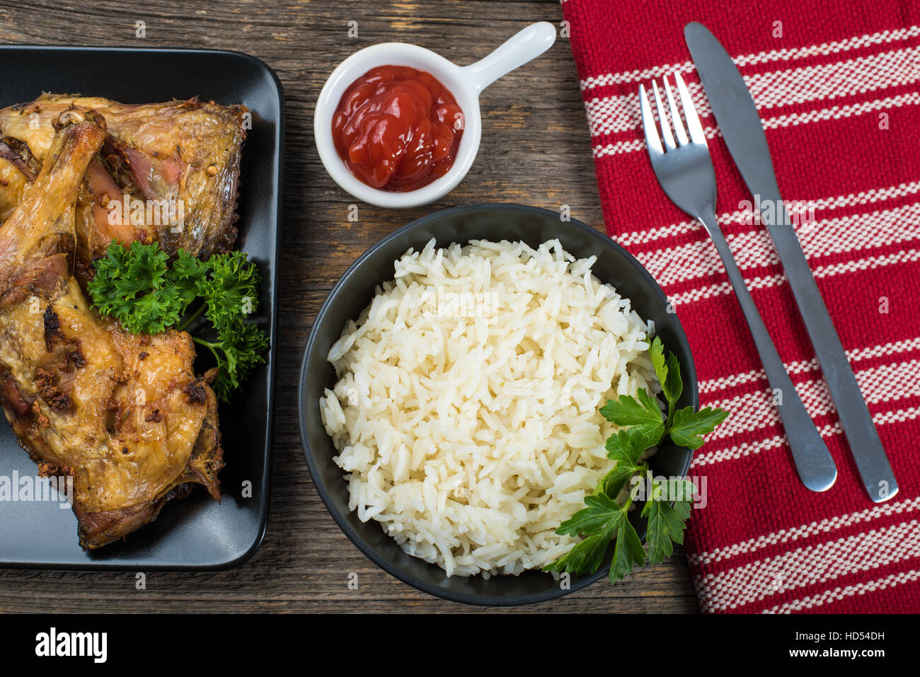 Gegrillte Hähnchenschenkel mit Reis auf den Tisch mit Besteck Stockfoto