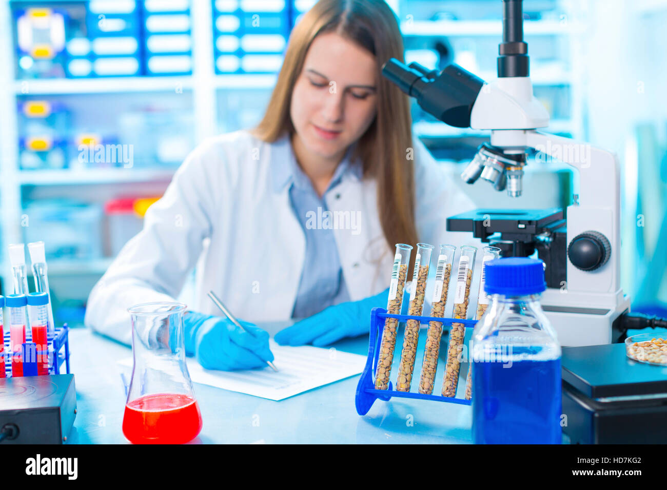 -MODELL VERÖFFENTLICHT. Junge Frau Essen in Qualitätskontrolllabor erforscht. Stockfoto