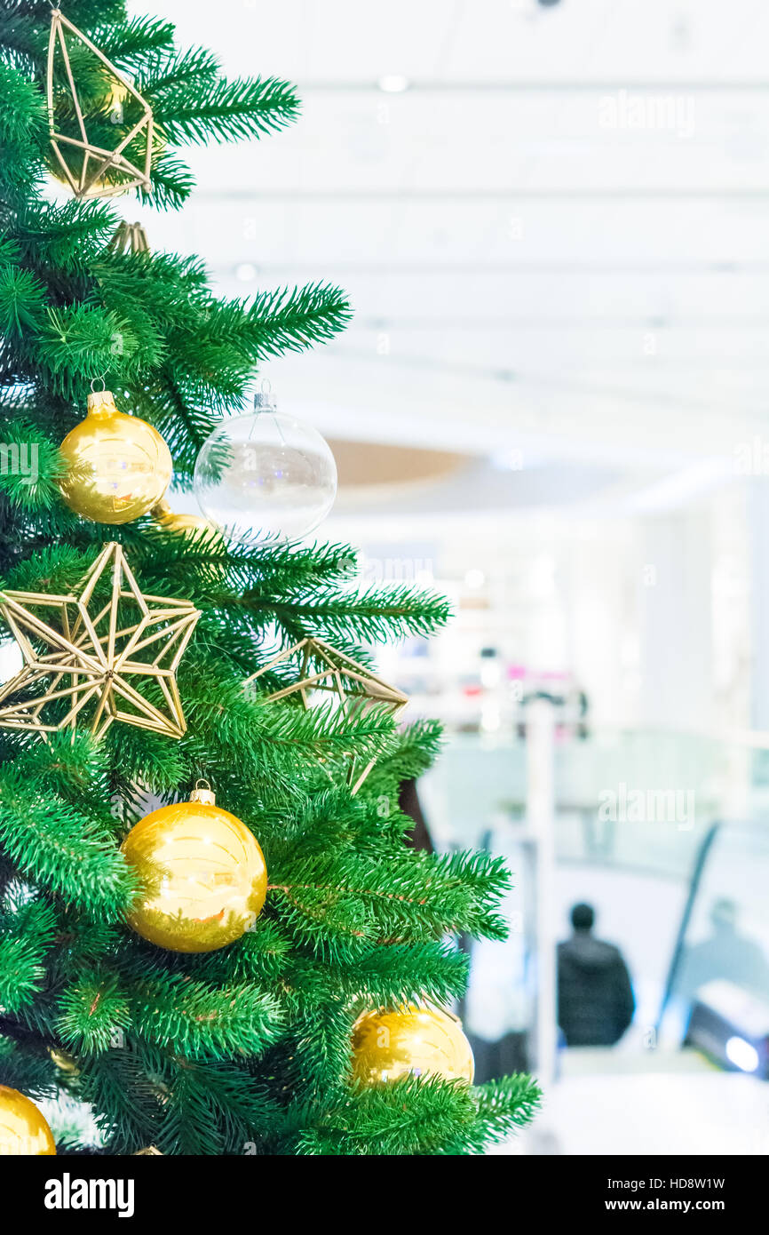 Weihnachtsbaum mit Golddekoration im Einkaufszentrum. Weihnachten-Abverkäufe in der Shopping Mall. Stockfoto