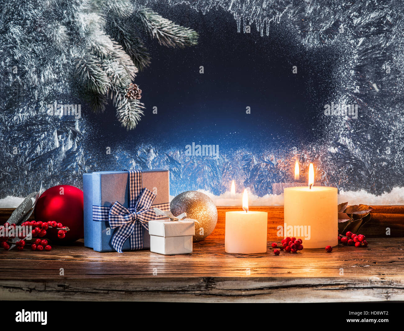 Geschenk-Boxen, Kerzenlicht und gefrorene Fenster. Weihnachten Hintergrund. Stockfoto