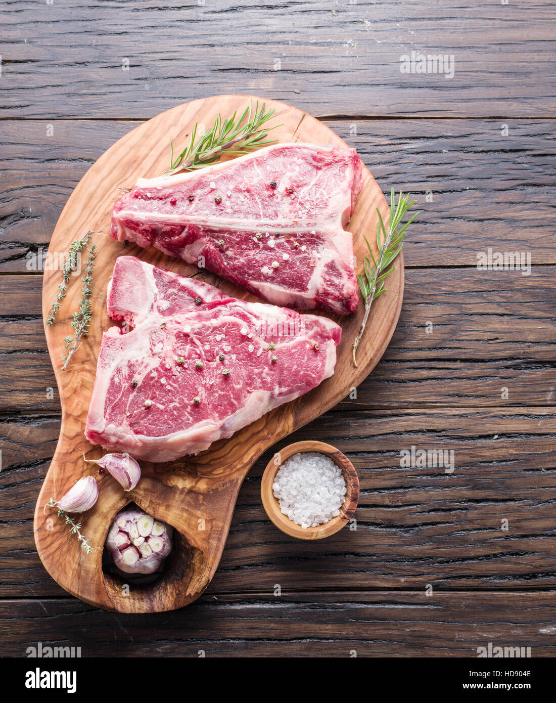 T-Bone Steak-mit Gewürzen auf dem Holzbrett. Stockfoto