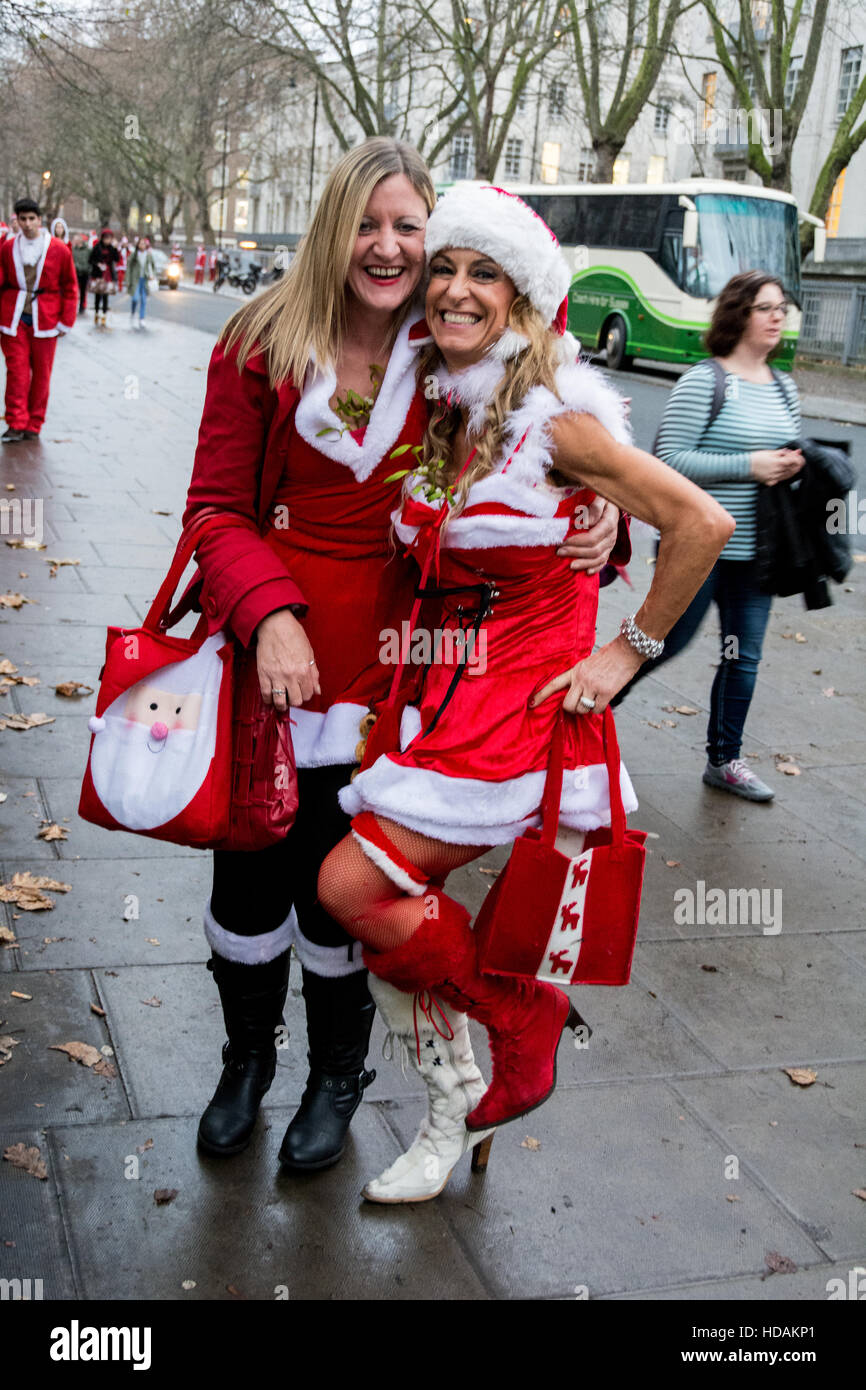 Zwei weibliche Santacon Santas auf den Straßen von London. Santacon ist eine nicht-religiöse Weihnachtsparade, die normalerweise jeden Dezember an einem Samstag in London stattfindet. Stockfoto