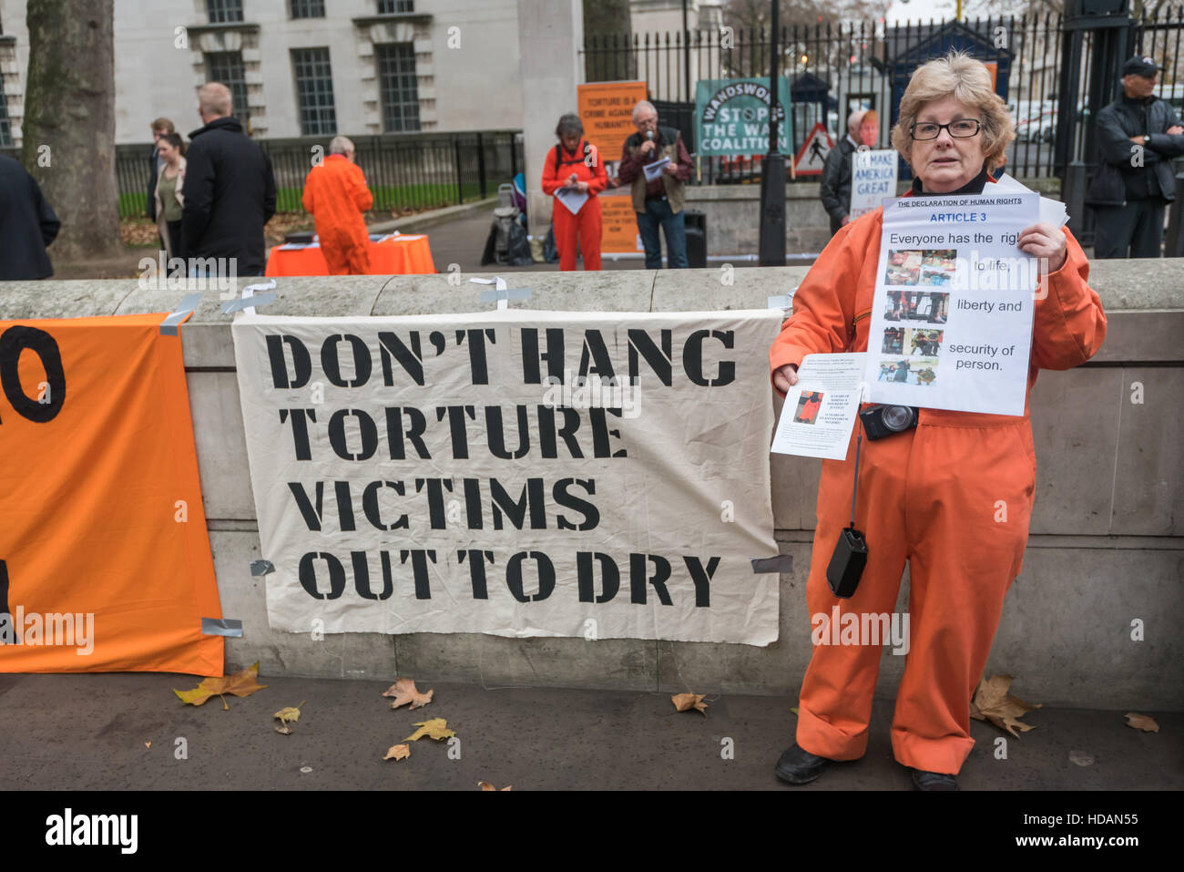London, UK. 10. Dezember 2016. Eine Frau in einem orange Sprunganzug hält ein Plakat mit Articlel 3 der Erklärung der Menschenrechte "Jeder hat das Recht auf Leben, Freiheit und Sicherheit der Person" in Guantanamo Gerechtigkeit Kampagne Protest am Tag der Menschenrechte der Vereinten Nationen gegenüber Downing St Berufung für ein Ende der Folter, der Schließung von Guantánamo und ein Ende der britischen Mitschuld an Folter. Peter Marshall/Alamy Live-Nachrichten Stockfoto