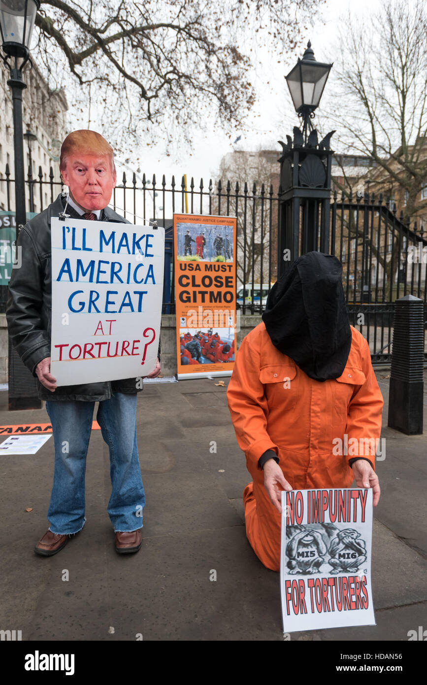 London, UK. 10. Dezember 2016. Ein Mann trägt eine Maske Trump und hält ein Plakat, das liest, "Ich mache große Amerika - Folter?" neben einer knienden Person in einem Sprunganzug Organe und schwarze Kapuze an Guantanamo Gerechtigkeit Kampagne Proteste am Tag der Menschenrechte der Vereinten Nationen gegenüber Downing St fordern ein Ende der Folter, der Schließung von Guantánamo und ein Ende der britischen Mitschuld an Folter. Peter Marshall/Alamy Live-Nachrichten Stockfoto
