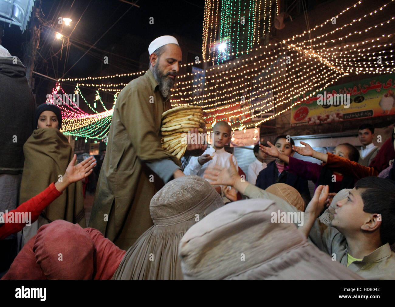 Peshawar. 11. Dezember 2016. Ein Mann verteilt kostenlose Verpflegung während der Feierlichkeiten des Mawlid al-Nabi, der Geburtstag des Propheten Mohamed in Nordwest-Pakistan Peshawar am 11. Dezember 2016. © Ahmad Sidique/Xinhua/Alamy Live-Nachrichten Stockfoto