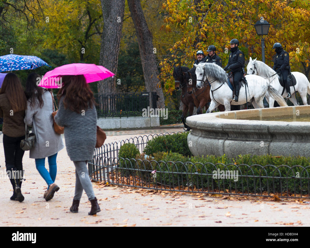 Brunnen im Parque del Retiro in Madrid, Spanien mit zwei Polizei Pferd vorbei. Stockfoto