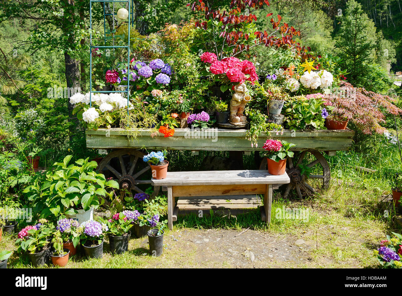 Dekorative Gartenbank, dekoriert mit Blumen in Töpfen Stockfotografie