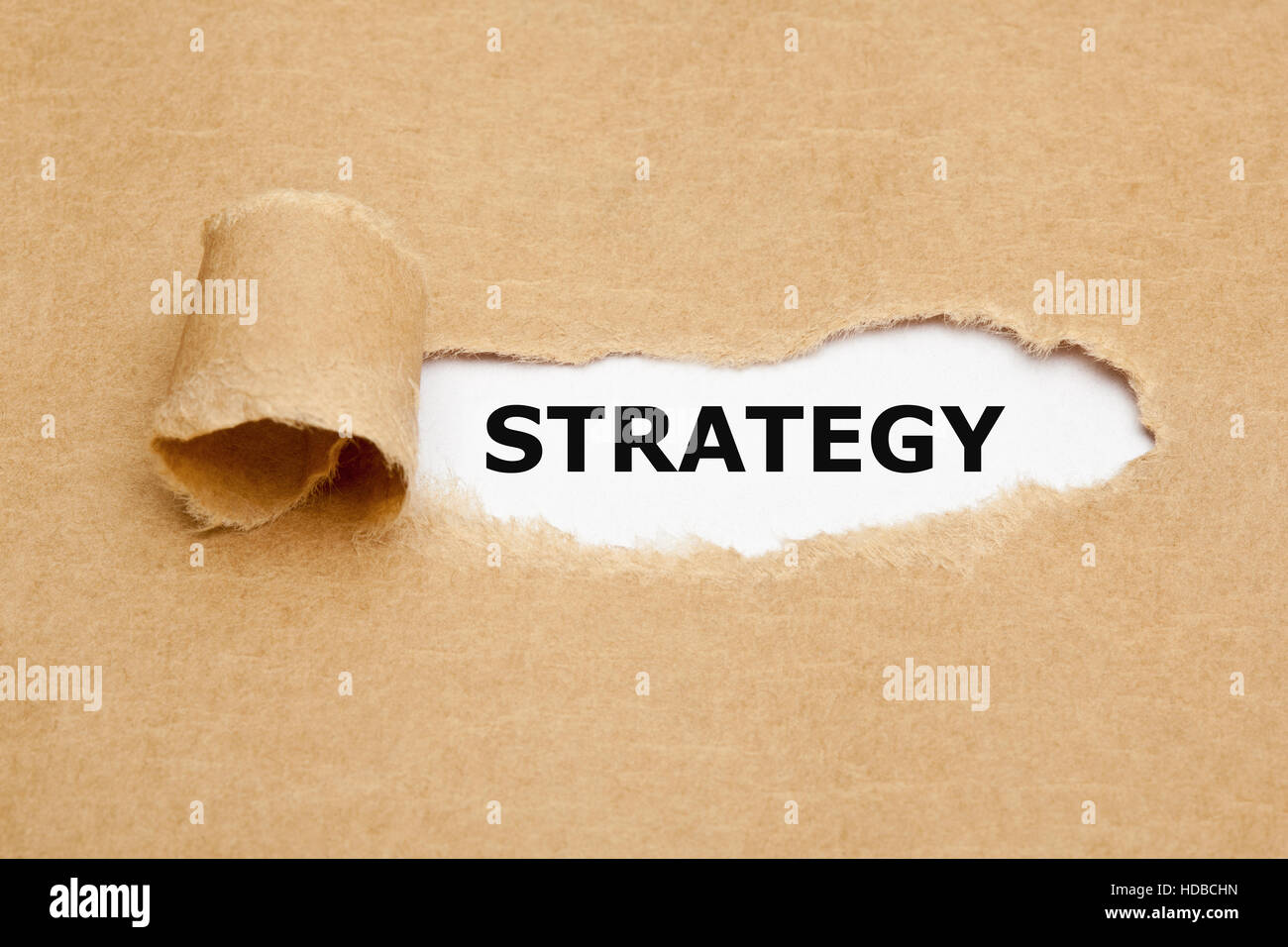 Das Wort Strategie erscheinen hinter braunes Papier zerrissen. Stockfoto